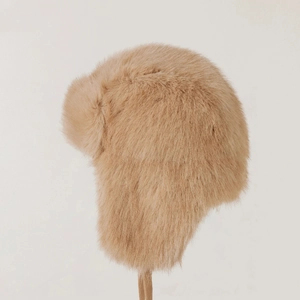 Macro side view of plush light coffee faux fur winter trapper hat with soft ear flaps