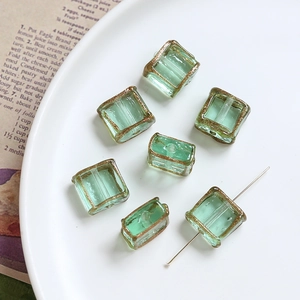 Detailed view of light green glass beads with gold edges for DIY jewelry making