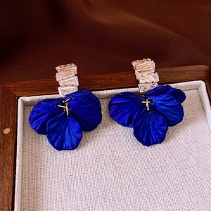 Royal blue flower earrings with rhinestone tops and gold accents on a display tray