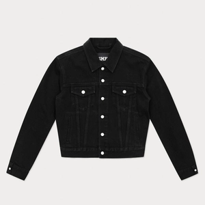 Détail d'une veste en jean noire avec boutons argentés, poches à rabat et coupe ajustée