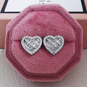 Macro shot of silver heart studs with pavé-set zircons in a pink velvet jewelry box