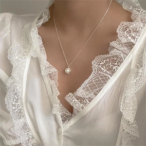 Elegant freshwater pearl necklace shown worn on neck with white lace shirt detail