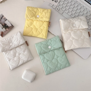 Flat lay of quilted heart pattern mini storage pouches with white snap button closure
