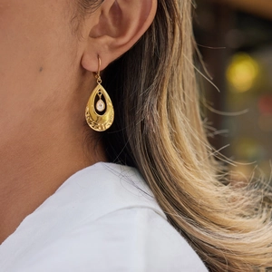 Elegant gold teardrop earrings with central zircon stone and geometric relief patterns