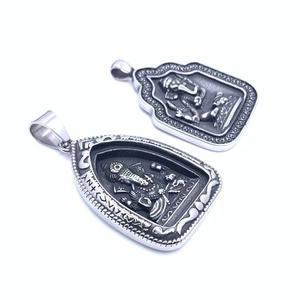 Detailed macro of vintage titanium steel Ganesha pendants with intricate carvings
