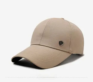 Detail of khaki baseball cap featuring fine plaid texture and a shield metal logo