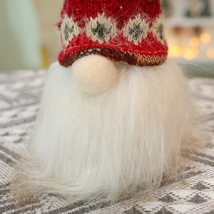 Close-up of a Christmas gnome with a red knitted hat and long white faux fur beard decoration