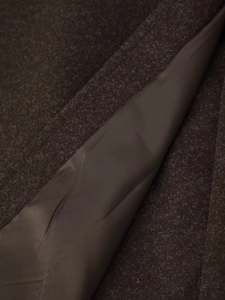 Macro shot of dark brown wool fabric texture with matching smooth satin lining