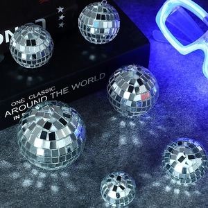 Close-up of assorted silver disco balls in various sizes on a dark textured surface