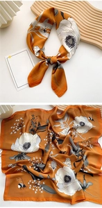 Detail of orange floral silk scarf with bee patterns and elegant bow styling