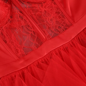 Détail de la dentelle rouge, de la ceinture en satin et des couches de tulle de la robe