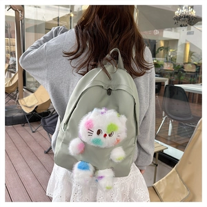 Vista dettagliata dello zaino in nylon verde chiaro con gatto di peluche indossato dalla modella
