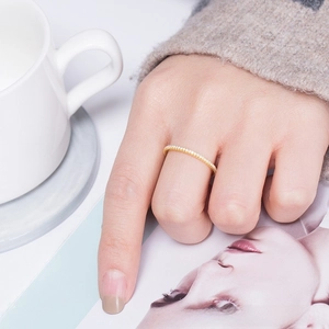 Close-up of a minimalist gold eternity ring with small sparkling cubic zirconia pavé