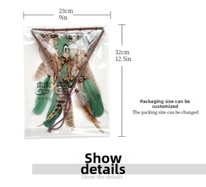 Detail view of triangular dream catcher with green feathers in clear packaging