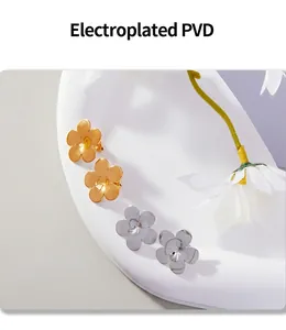 Detail view of gold and silver five-petal flower earrings with PVD electroplated finish