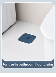 Square dark blue silicone floor drain cover with handle placed in a clean bathroom