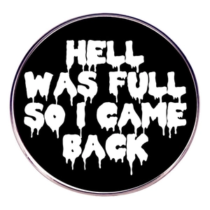 Round metal badge featuring HELL WAS FULL SO I CAME BACK slogan on black background