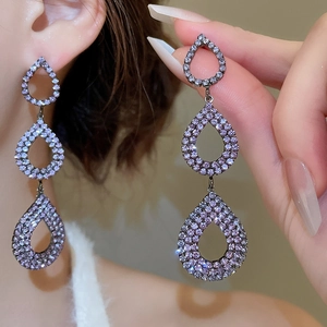 Detailed view of triple-layered purple crystal teardrop earrings in a tiered design