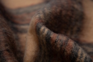 Macro shot of thick brown plaid scarf texture showing soft wool blend fabric fibers