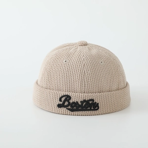 Détail du bonnet docker en velours beige avec broderie Boston et texture en maille fine