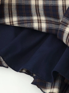 Close-up of the navy and beige plaid fabric with high-quality layered stitching details