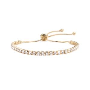 Dettaglio della chiusura a scorrimento regolabile su un bracciale tennis dorato con zirconi