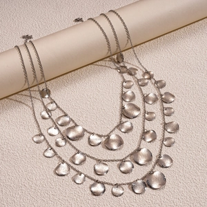 Macro shot of layered necklace featuring vintage metallic discs with hammer texture finish
