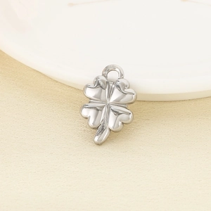 Close-up of a silver four-leaf clover pendant in polished stainless steel on a soft background