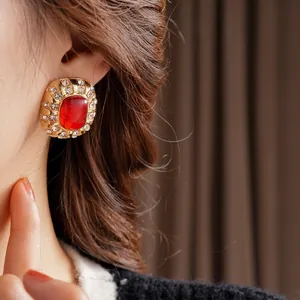 Vintage gold earrings with large red resin stone and shimmering crystal surround