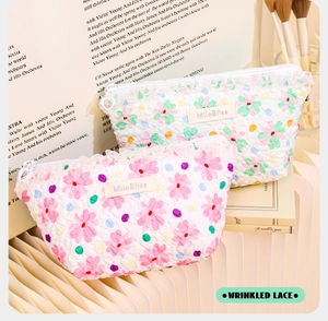Detail of wrinkled floral makeup bag with white lace trim and elegant metal zipper