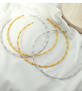 Detailed macro view of gold and silver bamboo design collars on white silky fabric