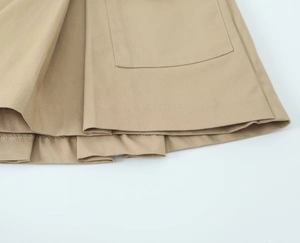 Detailed view of khaki cargo skirt hemline with pocket stitching and cotton twill texture