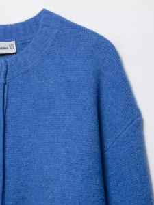 Detail of royal blue knit cardigan showing ribbed neckline and soft wool texture