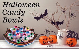 Halloween candy bowls with spider web design and pumpkin baskets on a wooden table