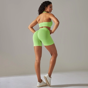 Back view of neon green seamless ribbed yoga set featuring halter bra and fitted shorts