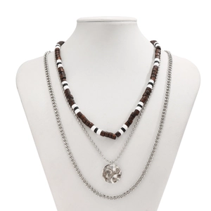 Close-up of triple-layer necklace featuring brown wood beads and silver chain with pendant
