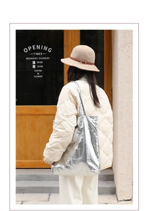Street style view of a silver metallic nylon tote bag styled with a casual winter outfit