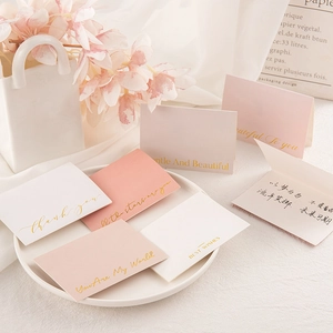 Detail of pink and white gold-stamped greeting cards with floral lifestyle decor