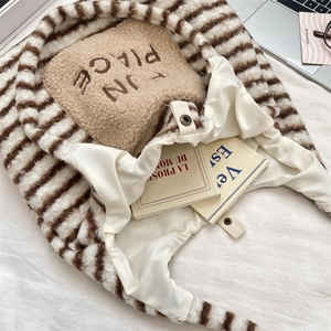 Vue macro de la texture rayée en peluche marron et blanc et des détails brodés