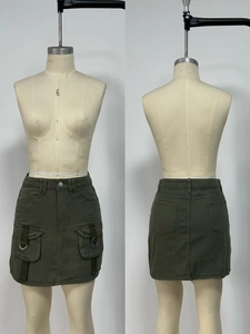 Detail of high waist army green cargo mini skirt with side flap pockets and metal rings