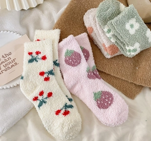 Detailed view of plush coral fleece socks with cherry and strawberry patterns