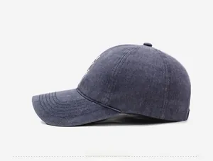 Side view detail of washed vintage denim baseball cap with stitched brim and air vents