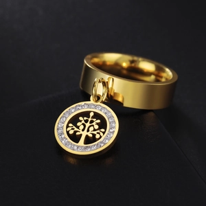 Detail of a gold stainless steel ring with a sparkling crystal-encrusted tree pendant