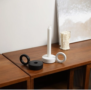 Minimalist ceramic candle holder set in black and white on a wooden tabletop