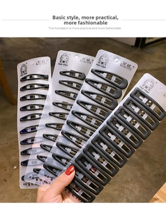 Detailed view of matte black metal hair clips and snap bars on a display card