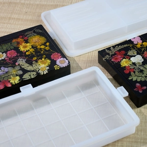 Détail du moule en silicone pour résine montrant des fleurs séchées colorées incrustées