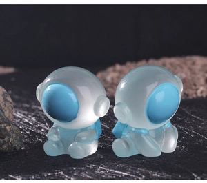 Close-up of luminous astronaut figurines on a textured moon surface background