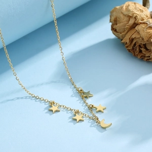 Detailed close-up of a gold star and moon pendant necklace on a soft blue background