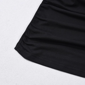 Detailed close-up of black ruched knit fabric texture and fine stitching craftsmanship