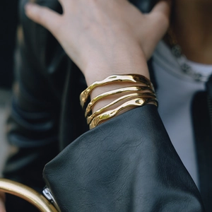 Minimalist 18K gold layered open bangle with a modern liquid metal wave design